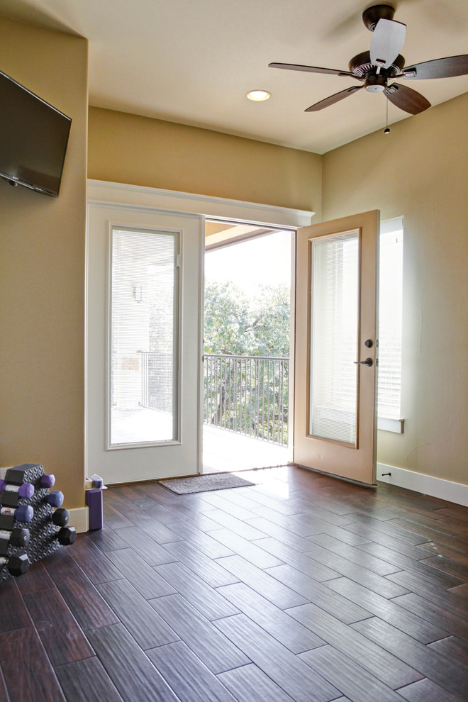 Multifunktionaler, Mittelgroßer Rustikaler Fitnessraum mit beiger Wandfarbe, dunklem Holzboden und braunem Boden in Austin