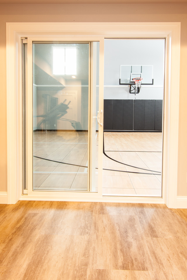 Réalisation d'un très grand terrain de sport intérieur design avec un mur gris et sol en stratifié.