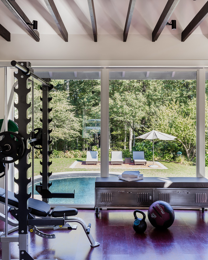 This is an example of a large contemporary multi-use home gym in Boston with white walls and cork flooring.