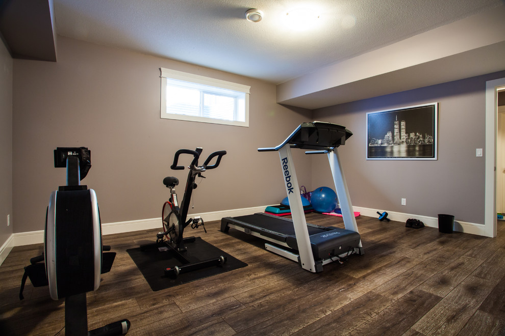 Photo of a medium sized contemporary home weight room in Edmonton with grey walls, medium hardwood flooring and brown floors.