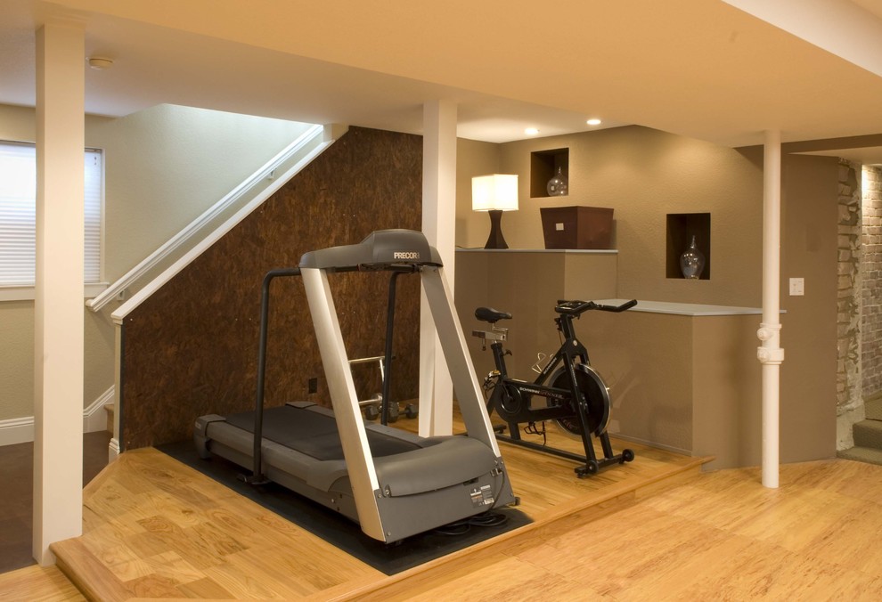 Moderner Fitnessraum mit beiger Wandfarbe, hellem Holzboden und gelbem Boden in Denver