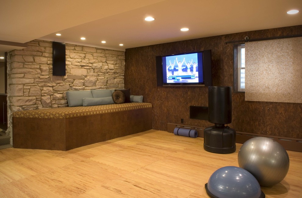 Moderner Fitnessraum mit brauner Wandfarbe, hellem Holzboden und orangem Boden in Denver