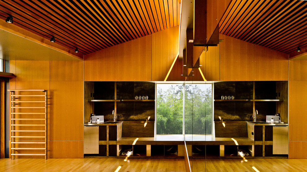 Modern home gym in Seattle with light hardwood flooring.