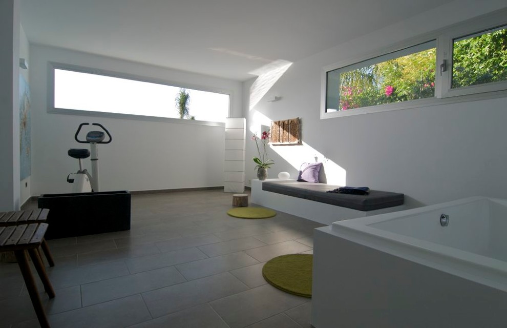 На фото: универсальный домашний тренажерный зал среднего размера в современном стиле с белыми стенами и полом из керамической плитки
