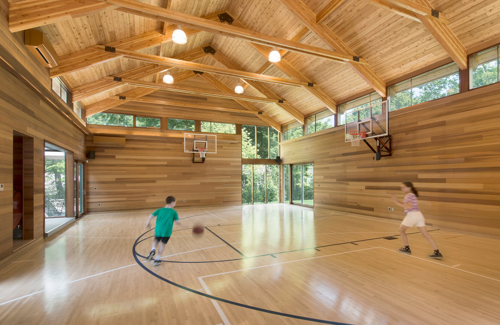 Geräumiger Moderner Fitnessraum mit Indoor-Sportplatz, beiger Wandfarbe und hellem Holzboden in Boston