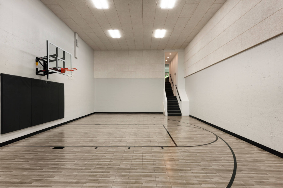 Идея дизайна: большой спортзал в стиле модернизм с белыми стенами и коричневым полом