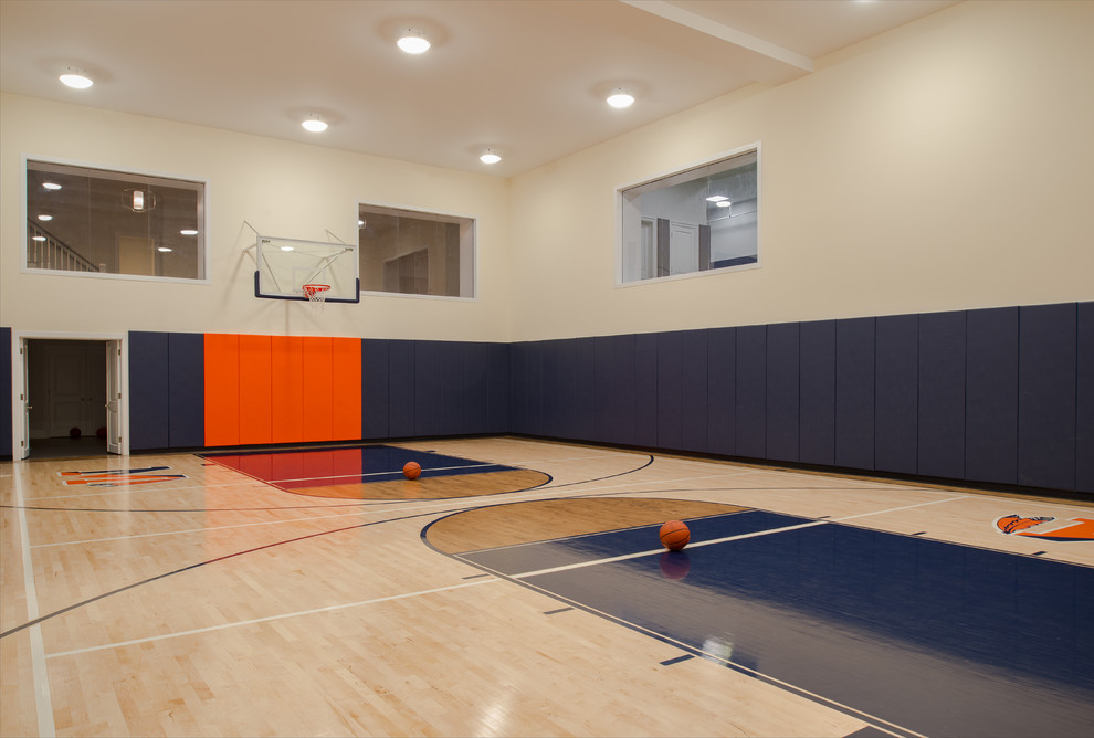 Geräumiger Fitnessraum mit Indoor-Sportplatz, beiger Wandfarbe, hellem Holzboden und beigem Boden in New York