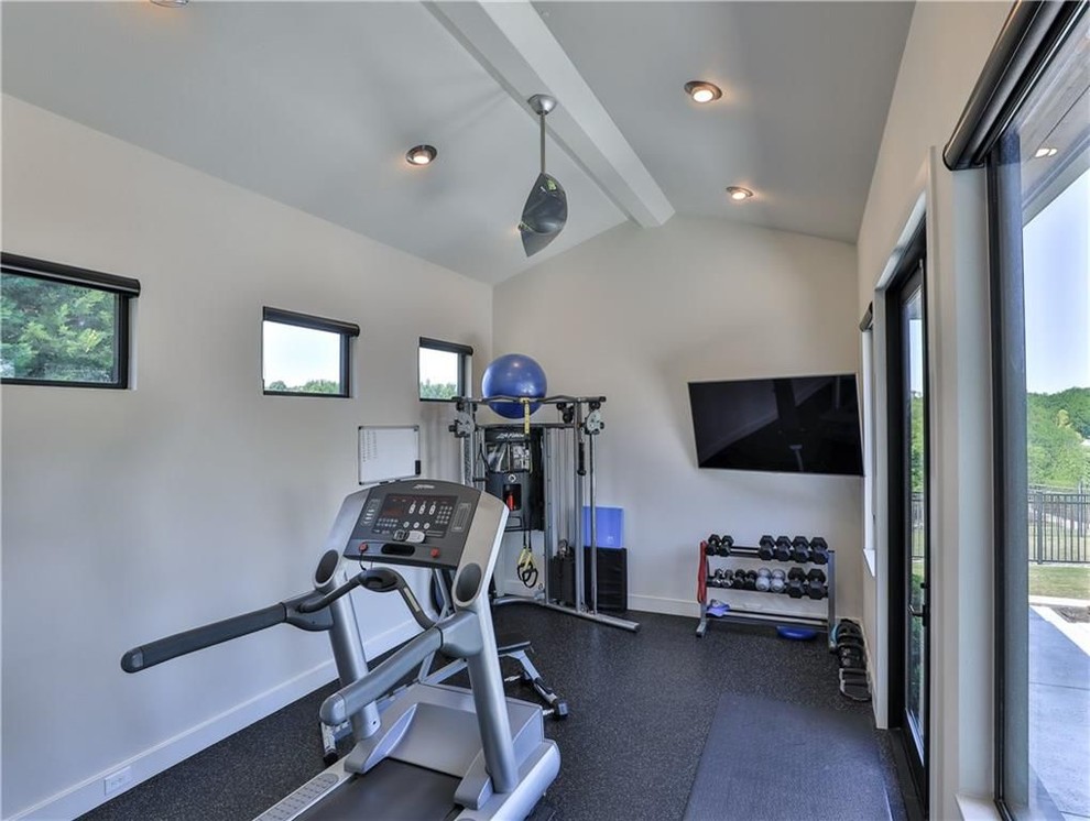 Exemple d'une petite salle de musculation tendance avec un mur beige, sol en béton ciré et un sol noir.