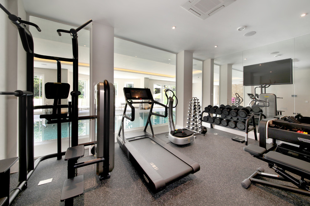 Contemporary multi-use home gym in Surrey with grey walls and grey floors.