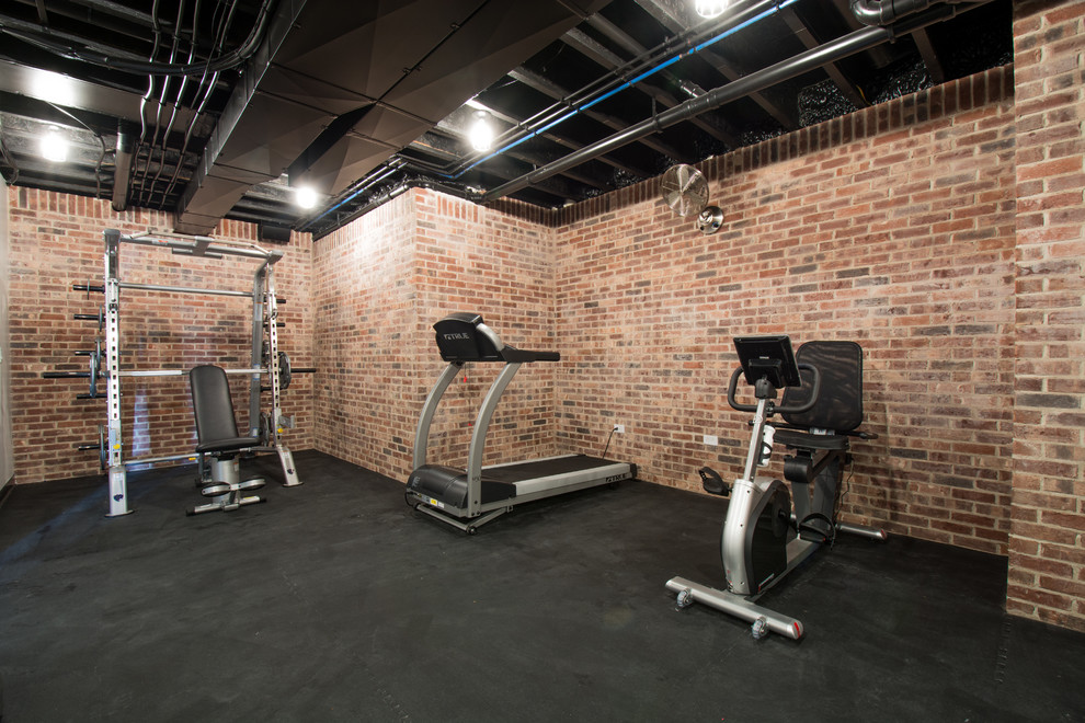 This is an example of a large classic home weight room in Louisville with multi-coloured walls and black floors.
