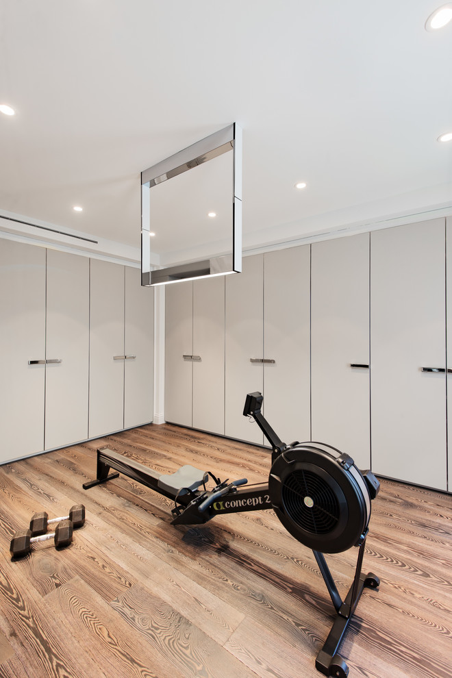 Multifunktionaler Moderner Fitnessraum mit grauer Wandfarbe und braunem Holzboden in Montreal