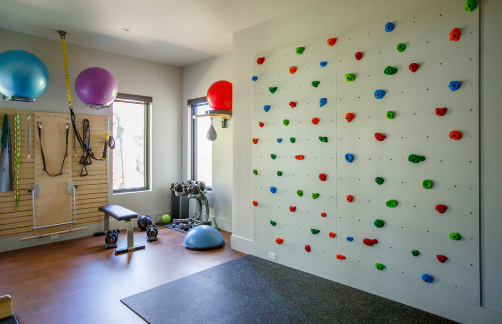 Moderner Fitnessraum mit Kletterwand, weißer Wandfarbe und braunem Boden in Jacksonville