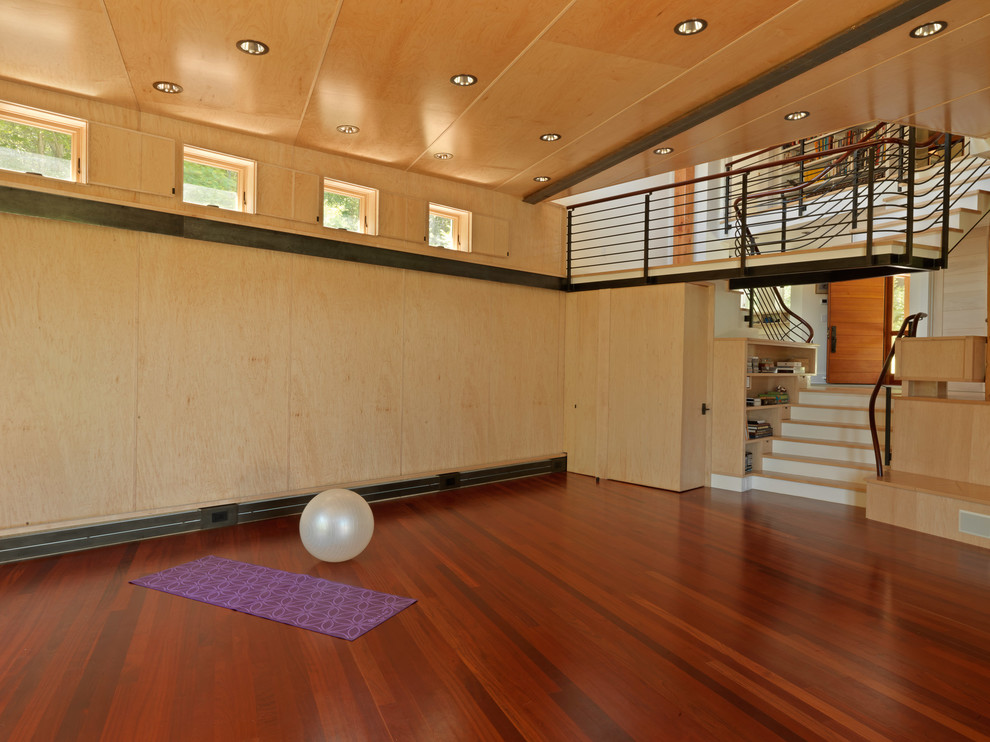 Modelo de estudio de yoga actual con suelo de madera en tonos medios