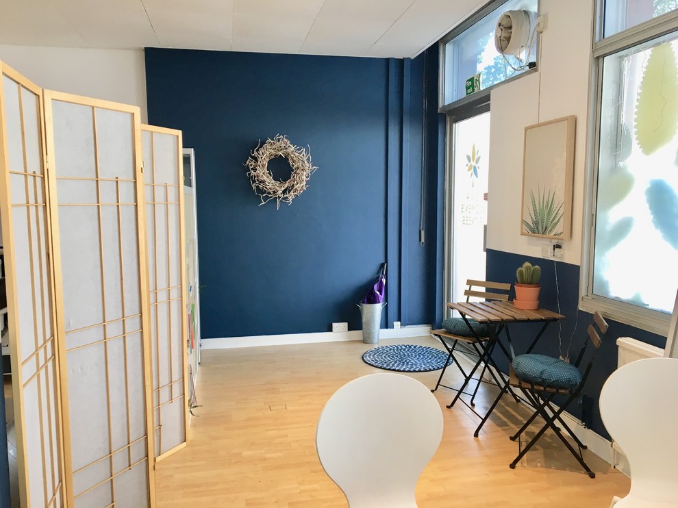 Skandinavischer Fitnessraum mit blauer Wandfarbe, Laminat und beigem Boden in London