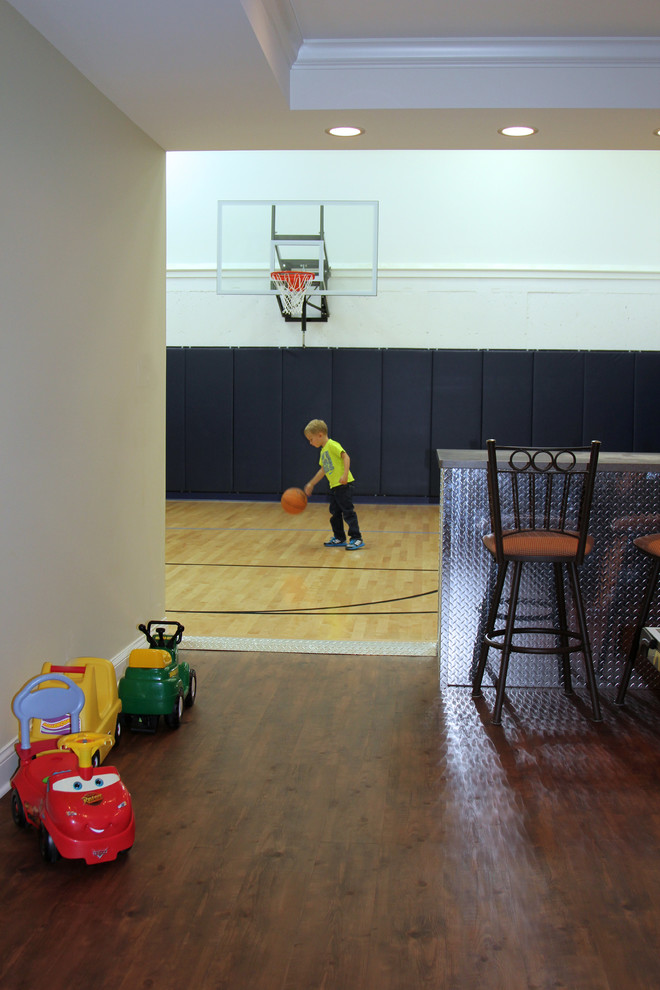 Großer Klassischer Fitnessraum mit Indoor-Sportplatz, weißer Wandfarbe und hellem Holzboden in Milwaukee