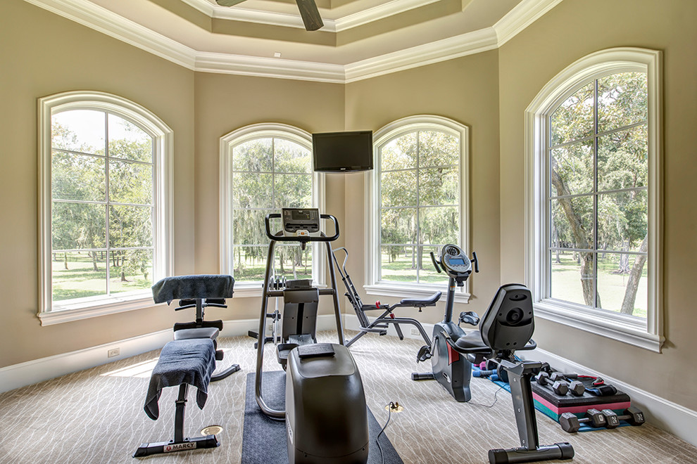 Photo of a large traditional multi-use home gym in Houston with beige walls, carpet and beige floors.