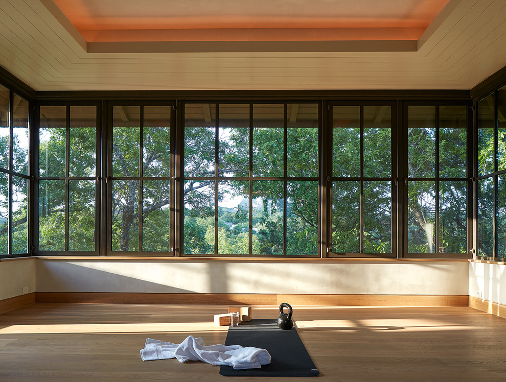 Ejemplo de estudio de yoga de tamaño medio con suelo de madera clara