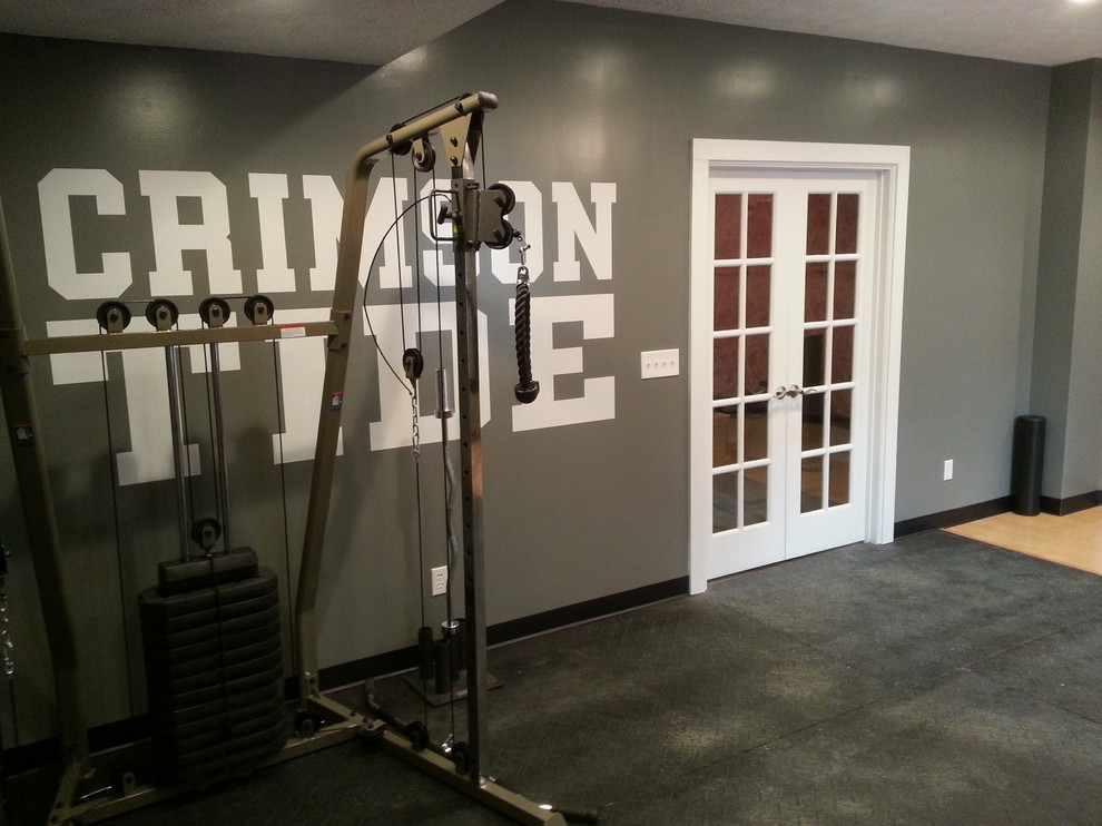 Ejemplo de sala de pesas actual de tamaño medio con paredes grises