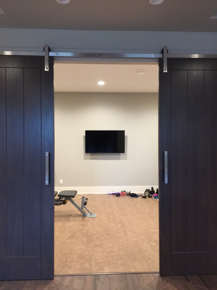 This is an example of a small modern multi-use home gym in Edmonton with grey walls, cork flooring and beige floors.