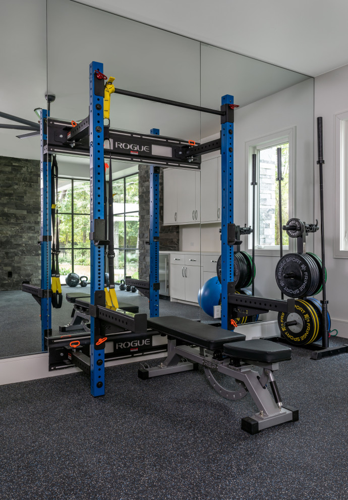 Exemple d'une très grande salle de musculation tendance avec un sol noir.