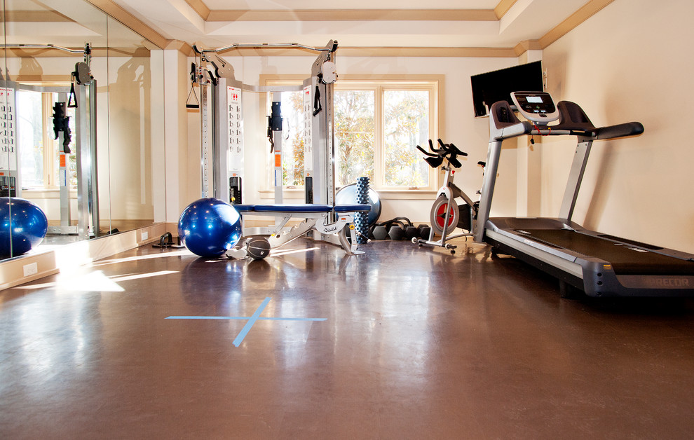 Photo of a traditional multi-use home gym in Nashville with beige walls and brown floors.