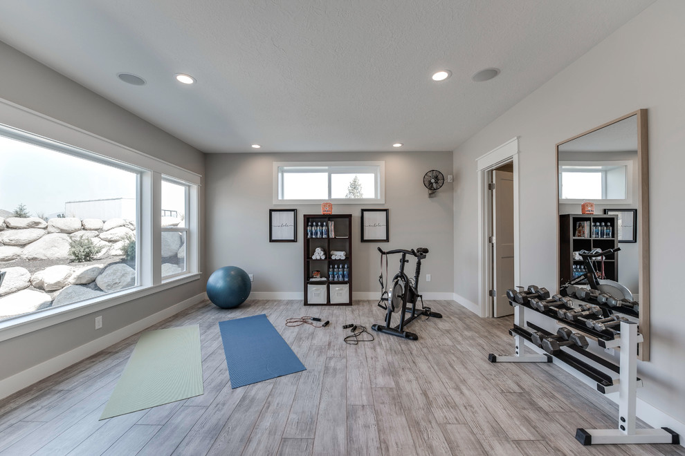 Large classic multi-use home gym in Salt Lake City with grey walls, laminate floors and grey floors.