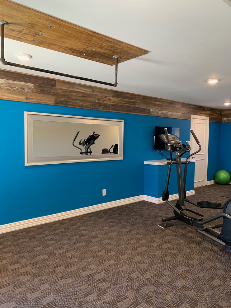 Inspiration pour une grande salle de musculation minimaliste avec un mur bleu, moquette et un sol marron.