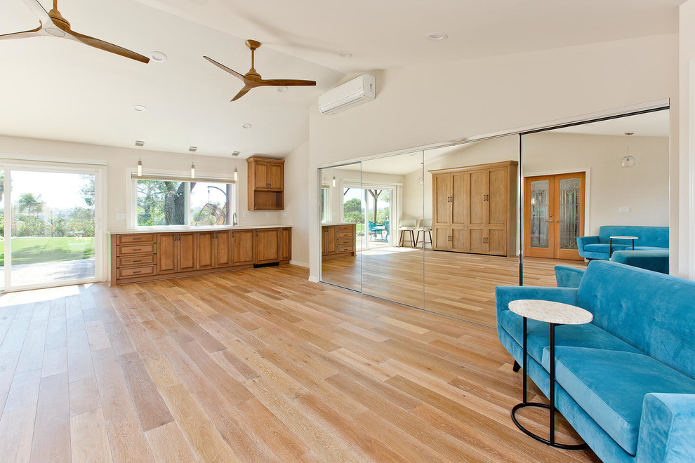 Großer Klassischer Yogaraum mit weißer Wandfarbe, braunem Holzboden und beigem Boden in Tampa