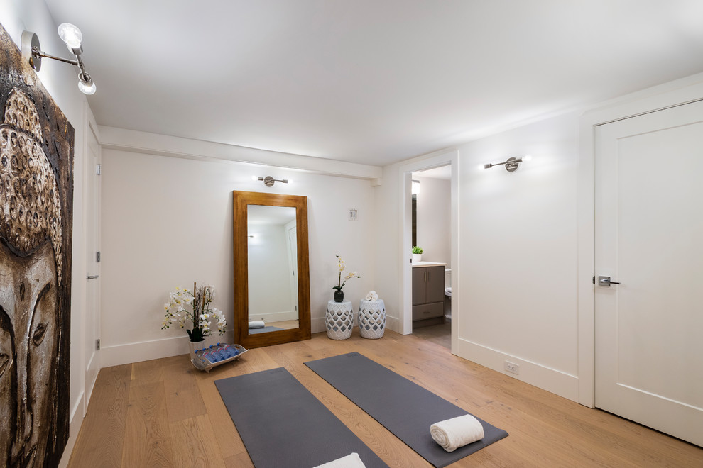 Esempio di uno studio yoga classico di medie dimensioni con pareti bianche, pavimento in legno massello medio e pavimento marrone
