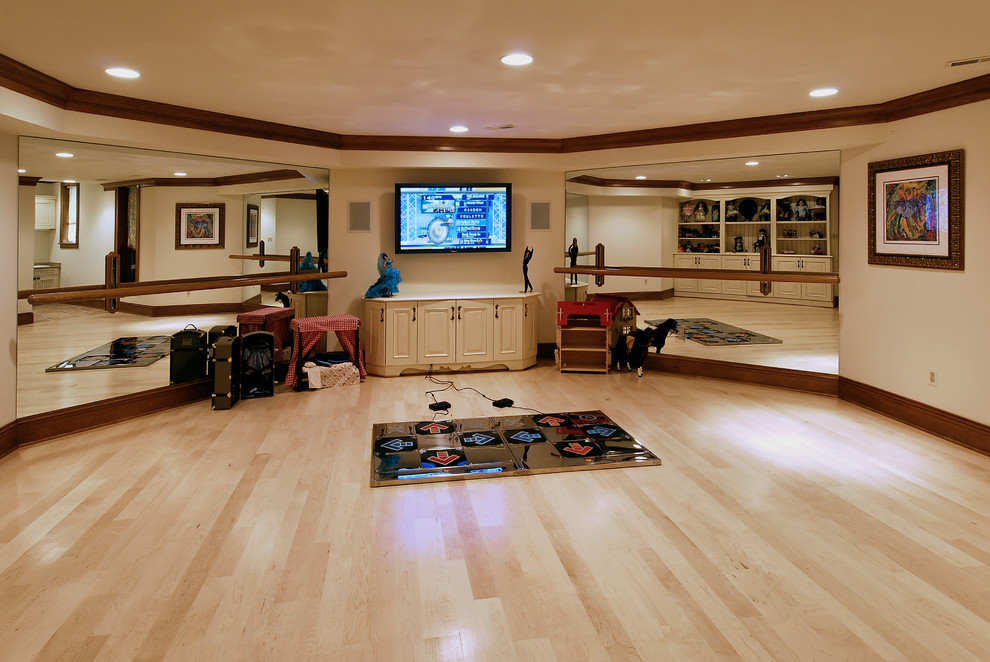 Classic home gym in DC Metro with beige walls and light hardwood flooring.