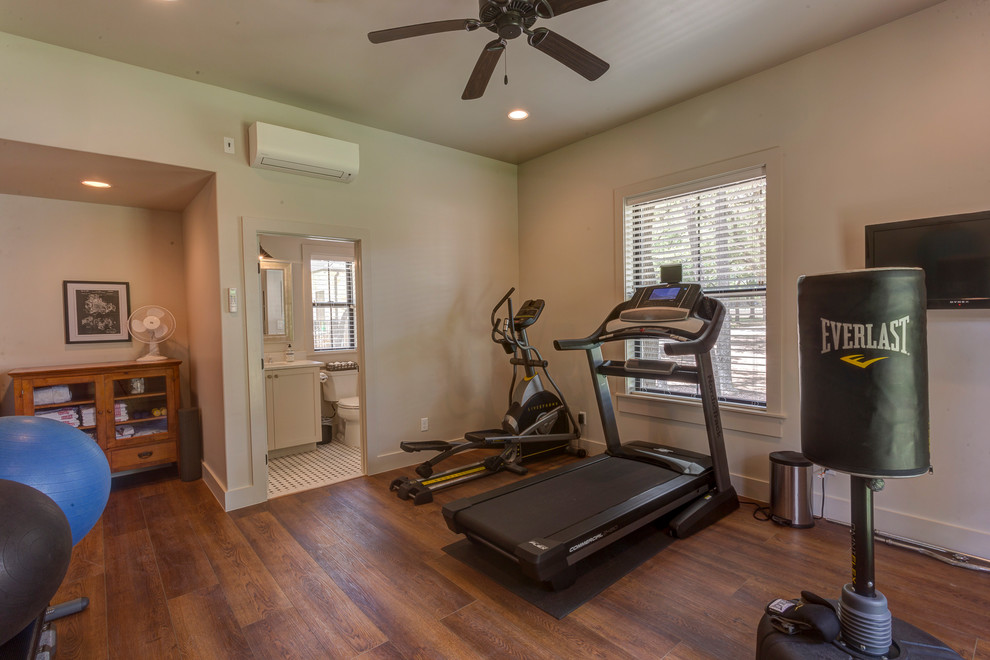 Example of a mid-sized cottage medium tone wood floor and brown floor multiuse home gym design in Austin with white walls