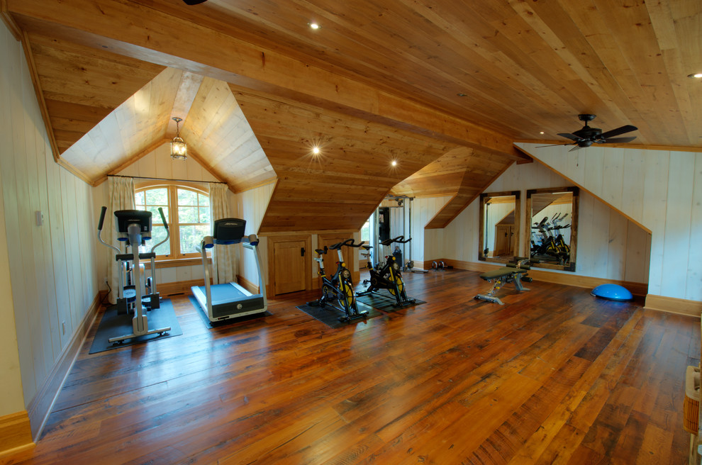 Multifunktionaler, Mittelgroßer Uriger Fitnessraum mit braunem Holzboden, beiger Wandfarbe und braunem Boden in Toronto