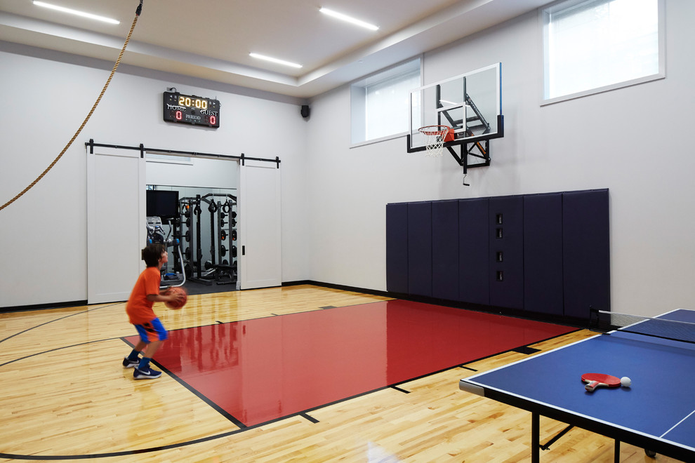 Moderner Fitnessraum mit Indoor-Sportplatz, weißer Wandfarbe, hellem Holzboden und beigem Boden in Chicago