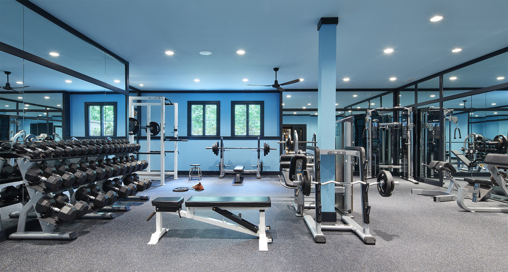 Idée de décoration pour une très grande salle de musculation tradition avec un mur bleu et un sol gris.