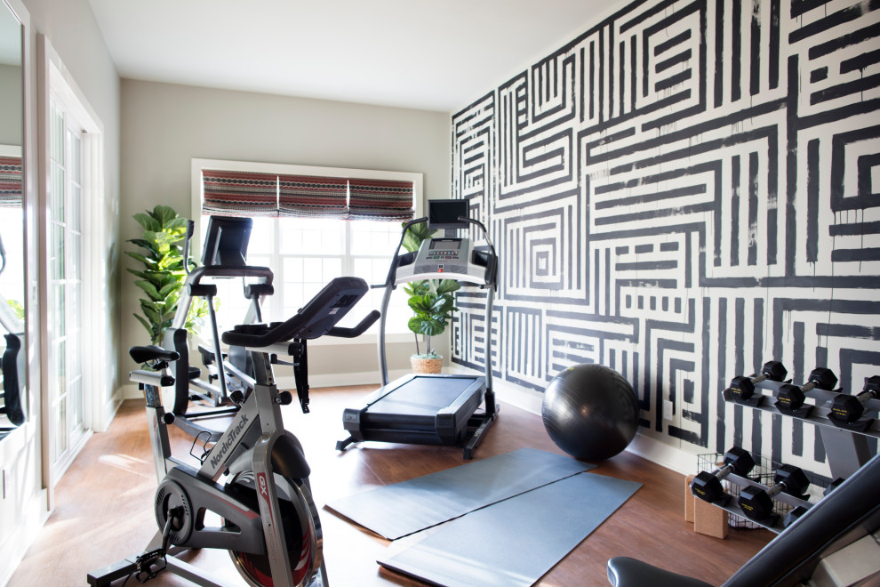 Esempio di una palestra in casa minimalista di medie dimensioni con pareti grigie, pavimento in laminato e pavimento marrone