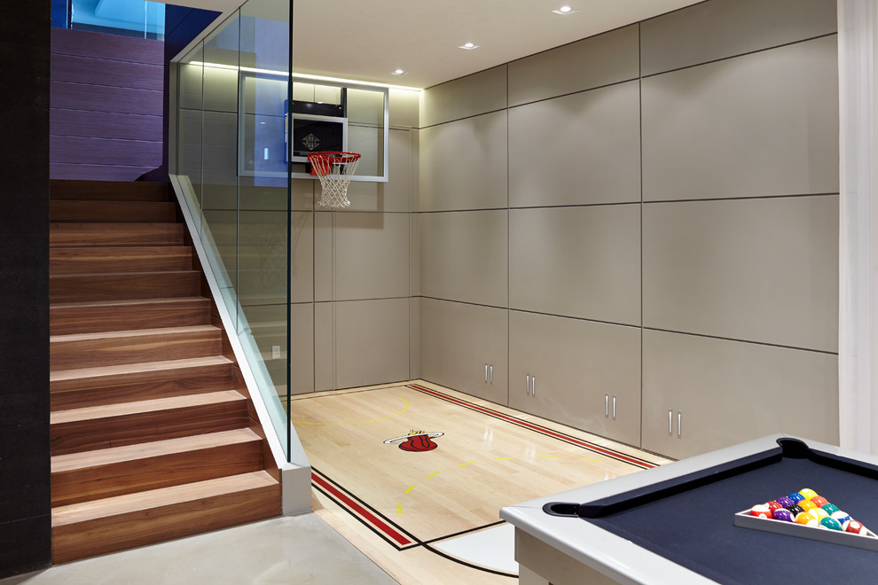 Contemporary indoor sports court in Miami with grey walls, light hardwood flooring and beige floors.