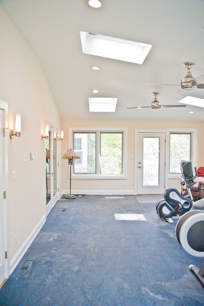 Large contemporary multi-use home gym in New York with white walls and concrete flooring.