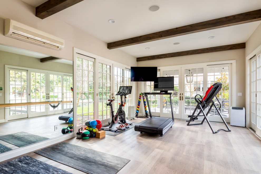 Example of a french country light wood floor, beige floor and exposed beam multiuse home gym design in San Francisco with beige walls