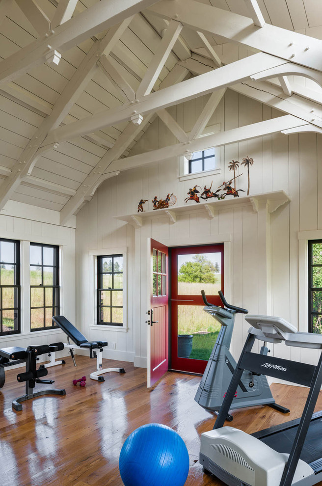 Photo of a rural home gym in Philadelphia with white walls and medium hardwood flooring.