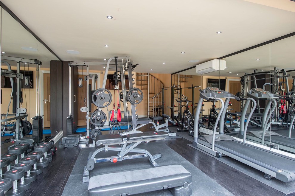 Medium sized contemporary multi-use home gym in Other with beige walls, dark hardwood flooring and black floors.