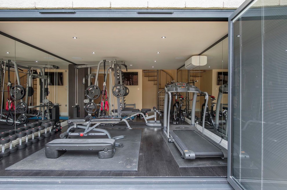 Multifunktionaler, Mittelgroßer Moderner Fitnessraum mit beiger Wandfarbe, schwarzem Boden und dunklem Holzboden in Sonstige