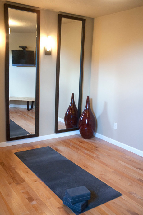 Ejemplo de estudio de yoga actual con paredes beige y suelo de madera clara