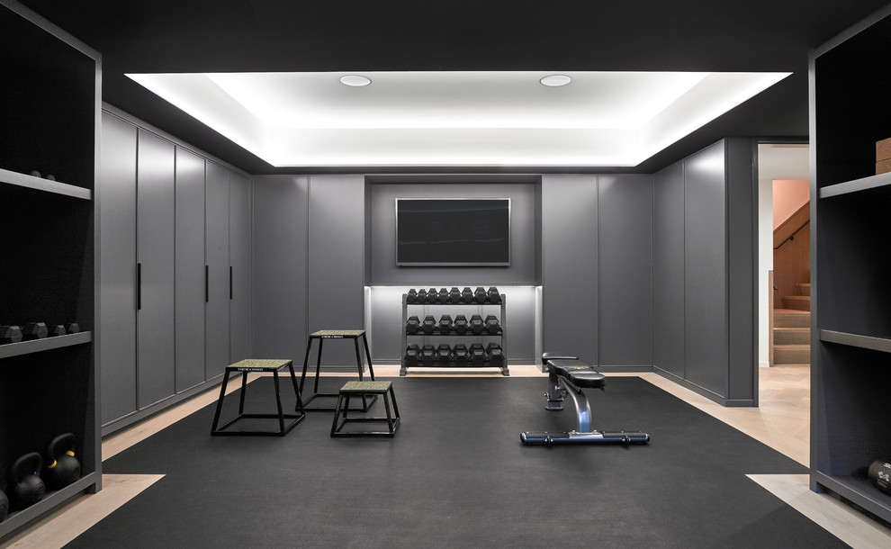 На фото: домашний тренажерный зал в современном стиле с тренажерами, серыми стенами и черным полом с