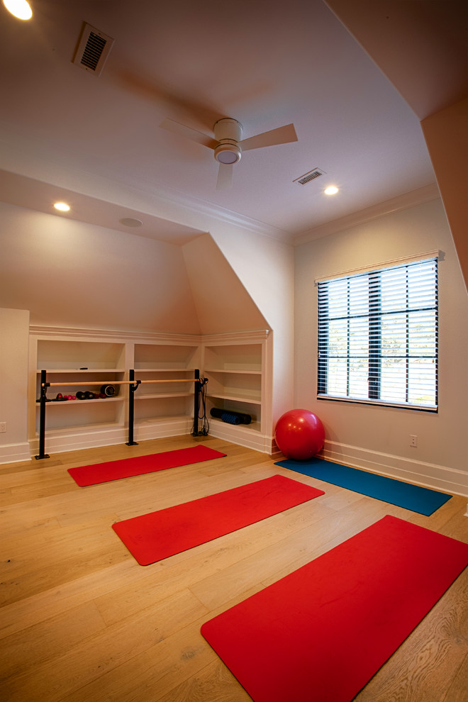 Esempio di uno studio yoga chic di medie dimensioni con pareti beige, pavimento in legno massello medio e pavimento marrone