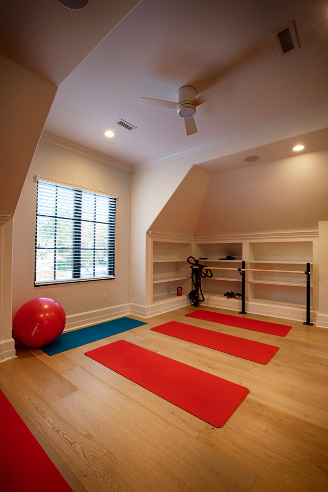 Mittelgroßer Klassischer Yogaraum mit beiger Wandfarbe, braunem Holzboden und braunem Boden in New York