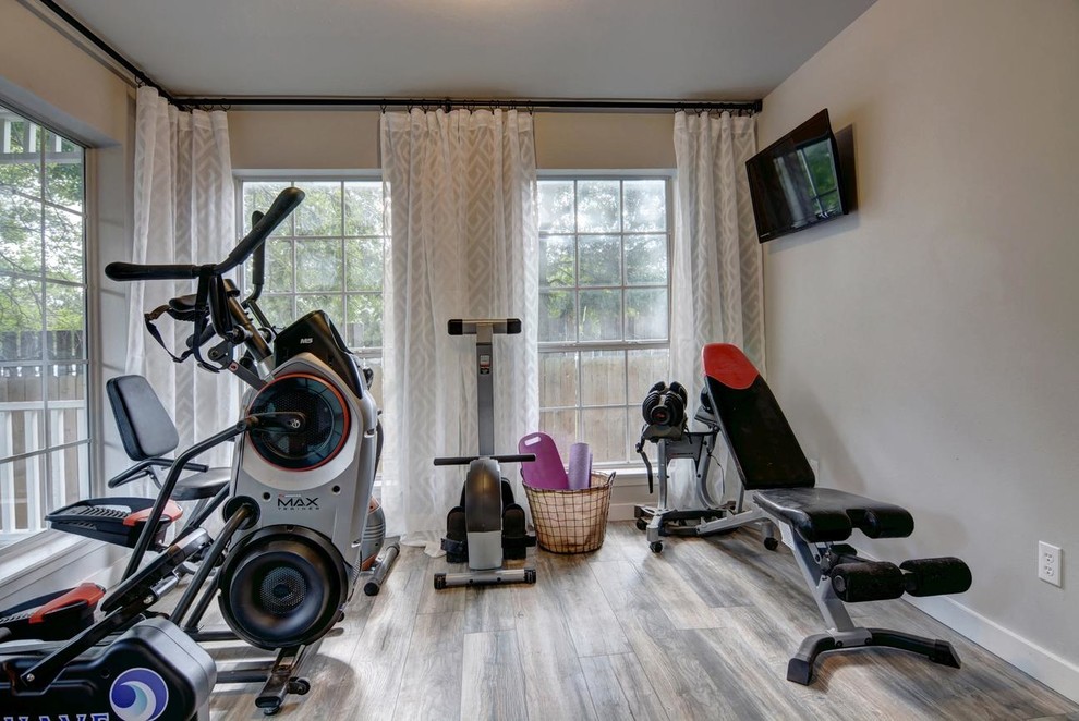 Example of a mid-sized transitional medium tone wood floor and gray floor multiuse home gym design in Austin with gray walls