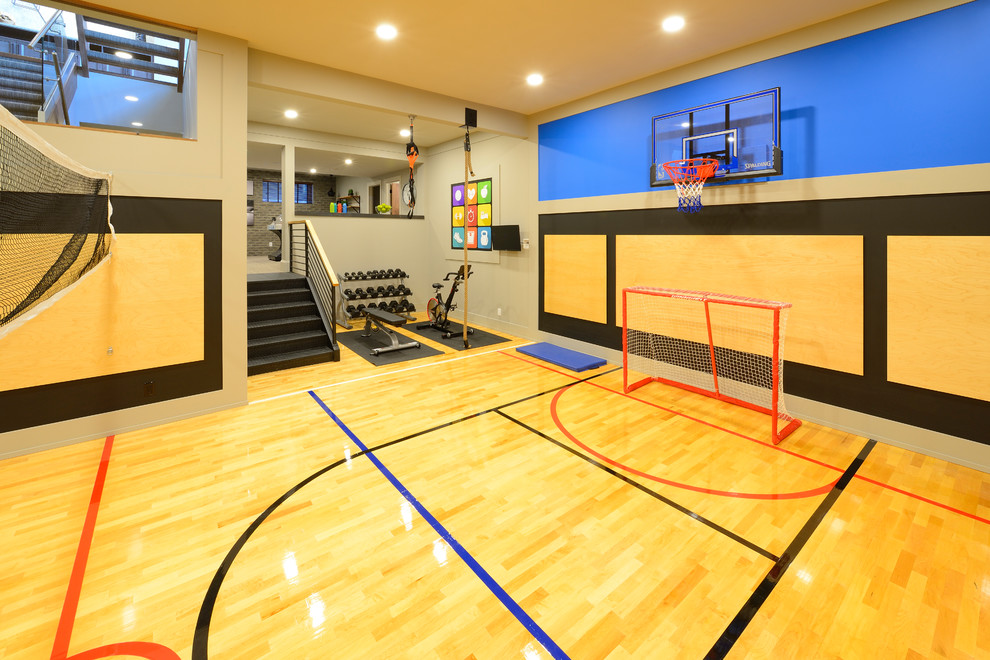 Großer Klassischer Fitnessraum mit Indoor-Sportplatz, grauer Wandfarbe, hellem Holzboden und gelbem Boden in Calgary