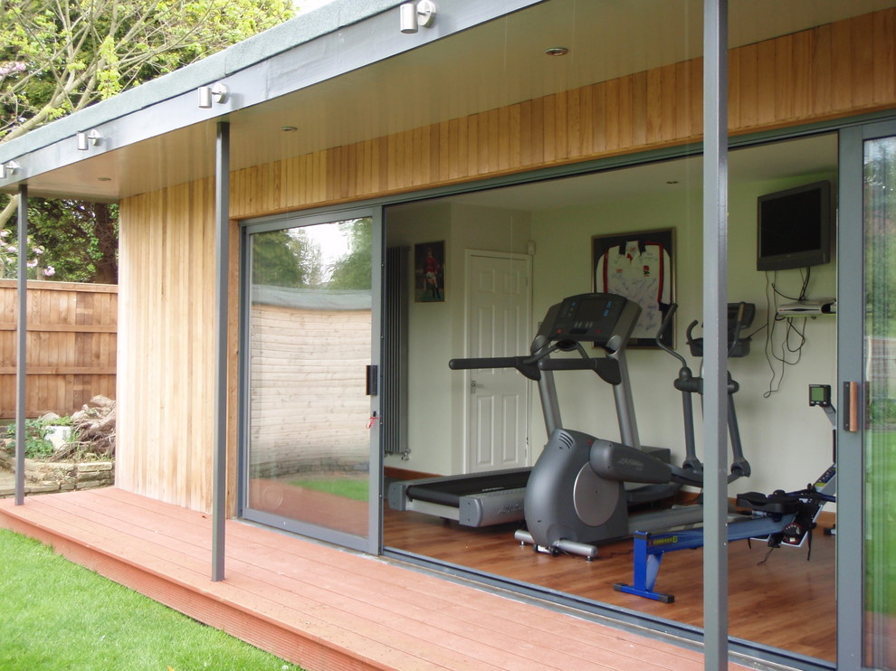 This is an example of a medium sized modern home gym in Essex with laminate floors.