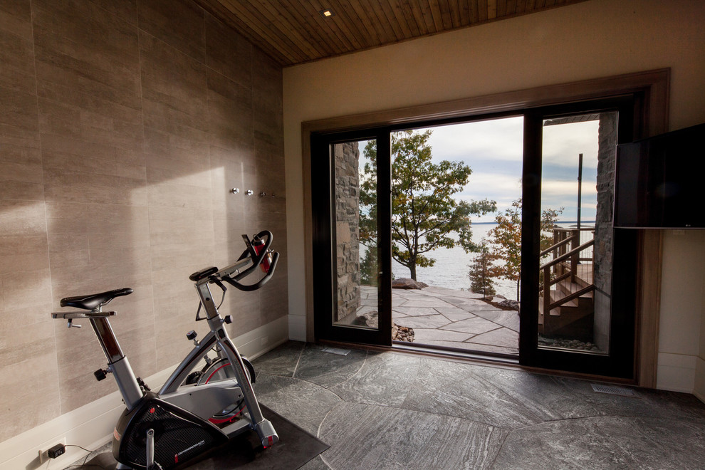 Example of a small mountain style slate floor and gray floor home weight room design in Toronto with white walls