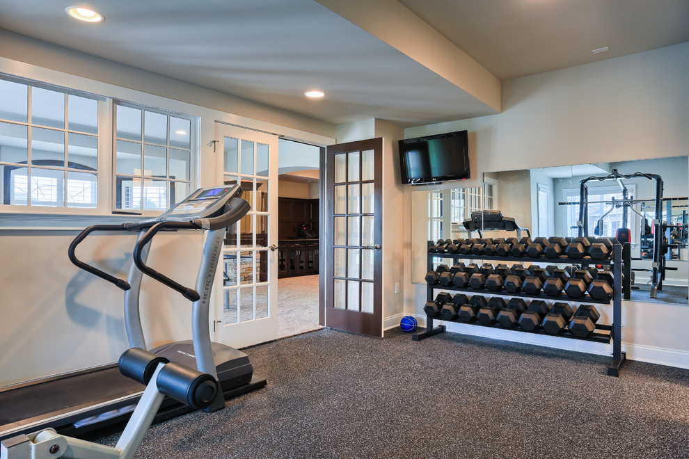 Photo of an expansive traditional home gym in Other with beige walls and carpet.